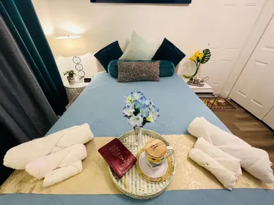 a blue table with a bowl of flowers and a book at Relax 521- at the side in Miami