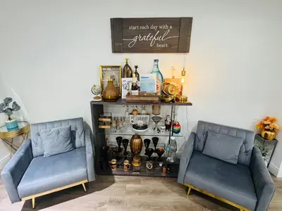 two blue chairs in a room with a shelf with bottles at Relax 521 in Miami