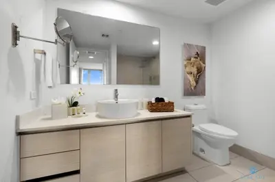 a bathroom with a sink and a toilet and a mirror at Infinite View and Balcony with Pool, Gym, Near Beach in Hallandale Beach