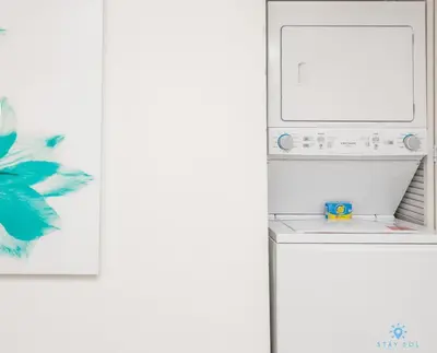 a washer and dryer in a kitchen next to a wall at Infinite View and Balcony with Pool, Gym, Near Beach in Hallandale Beach