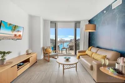 a living room with a couch and a table at Infinite View with Balcony, Gym, Pool in Hallandale Beach