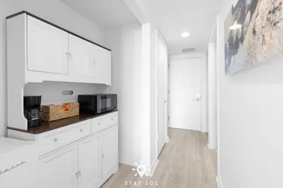a kitchen with white cabinets and a microwave at Infinite View - Balcony - Pool - Gym - Near Beach in Hallandale Beach