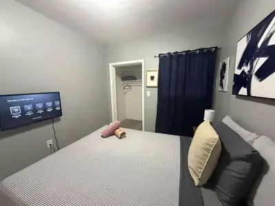 a bedroom with a bed and a tv on the wall at Modern cozy home with private patio - Sleeps 6 in Miami