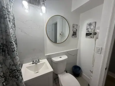 a bathroom with a toilet and a sink and a mirror at Modern cozy home with private patio - Sleeps 6 in Miami