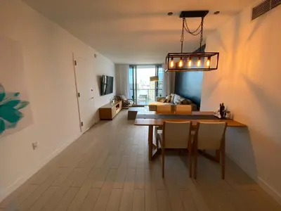 a dining room and living room with a table and chairs at Stylish Miami Beach Getaway, Ocean Views & Gourmet Kitchen -12A in Hallandale Beach