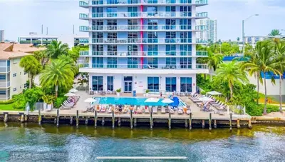a resort with a dock with chairs and a pool at Stylish Miami Beach Getaway, Ocean Views & Gourmet Kitchen -12A in Hallandale Beach