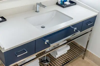 a bathroom vanity with a white sink and blue cabinets at Fontainebleau Hotel Ocean View Fits 6! 1 BED/2 BA in Miami Beach