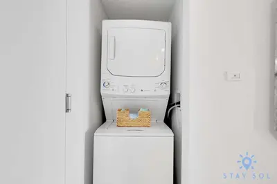 a washer and dryer sitting on top of a refrigerator at Spacious 2BR Condo, Sleeps 6, Beachwalk Resort in Hallandale Beach
