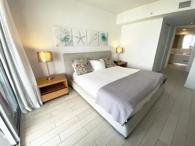 a bedroom with a large bed and two lamps on tables at Premium Oceanview Living Full Kitchen & Miami Chic Vibes -14 A in Hallandale Beach