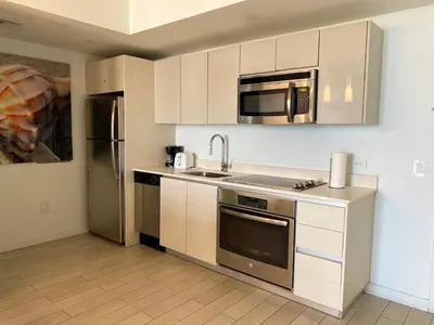a kitchen with a sink and a microwave at Boutique-Style Miami Apt, Comfort, Design & Sea View -26A in Hallandale Beach