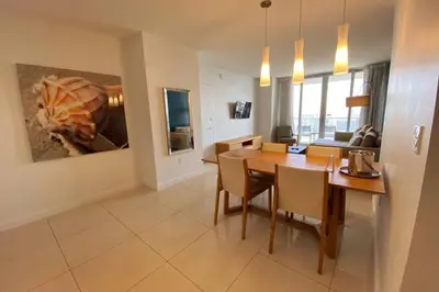 a dining room and living room with a table and chairs at Upscale Beach Apartment, Style, Views & Complete Kitchen -28A in Hallandale Beach