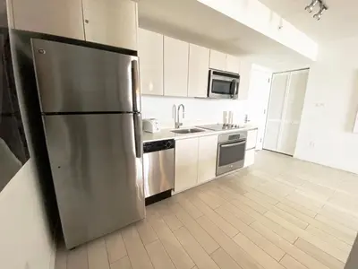 a large kitchen with a stainless steel refrigerator at Upscale Beach Apartment, Style, Views & Complete Kitchen -28A in Hallandale Beach