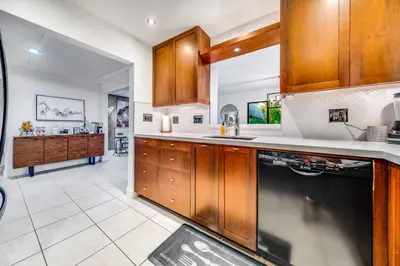 a kitchen with wooden cabinets and a counter top at Pool and Waterfront Oasis in Fort Lauderdale