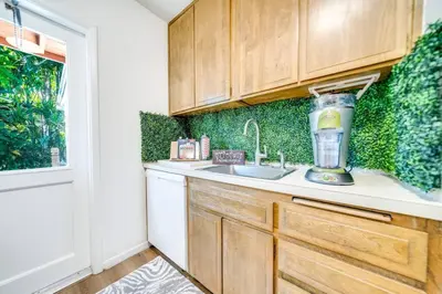 a kitchen with wooden cabinets and a blender on the counter at Tropical Jungle Pool Oasis in Fort Lauderdale