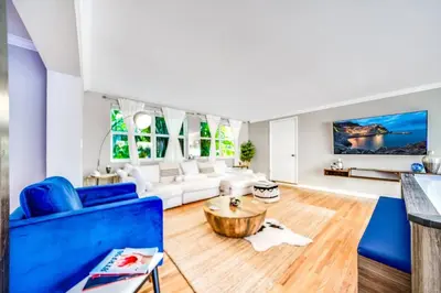 a living room with a blue couch and a table at Tropical Jungle Pool Oasis in Fort Lauderdale