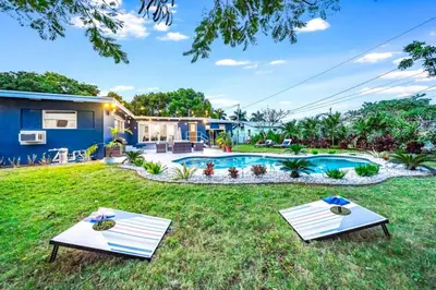 a backyard with a swimming pool and a house at Pool and Beach Relaxing Close to Everything in Dania Beach