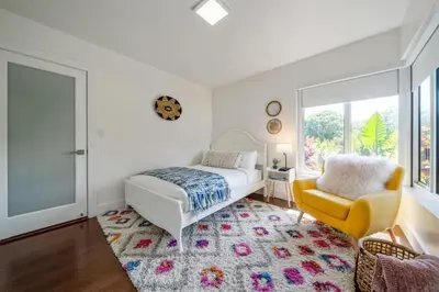 a bedroom with a bed and a yellow chair at Boho House - Stylist Home with Parking and large Yard in Miami