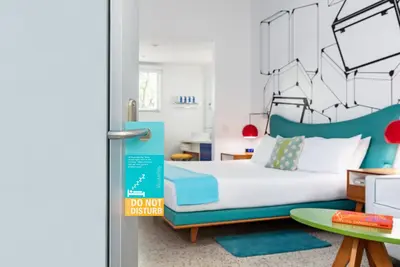 a bedroom with a bed and a sign that says do not disturb at The Vagabond Hotel Miami in Miami