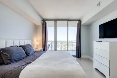 a bedroom with a large bed and a large window at Stunning Penthouse Suite Waterfront 2BD 2BA in Hallandale Beach