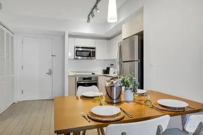 a kitchen with a wooden table with plates on it at Apartment with Balcony, Gym & Near Beach in Hallandale Beach