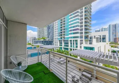 a balcony with chairs and a view of a city at Amazing Condo with Pool at Midblock Miami in Miami