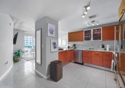 a large kitchen with wooden cabinets and stainless steel appliances at Amazing Condo with Pool at Midblock Miami in Miami