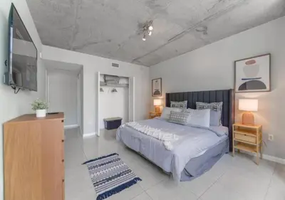 a bedroom with a large bed and a tv at Amazing Condo with Pool at Midblock Miami in Miami