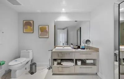 a bathroom with a sink and a toilet and a mirror at Lyfe Oceanview Resort Luxury 2 Bedroom Unit in Hollywood