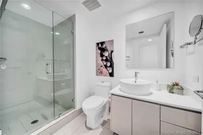 a bathroom with a toilet and a sink and a shower at Chic Beach Studio Walk to Shore Sleeps 4 -14B in Hallandale Beach