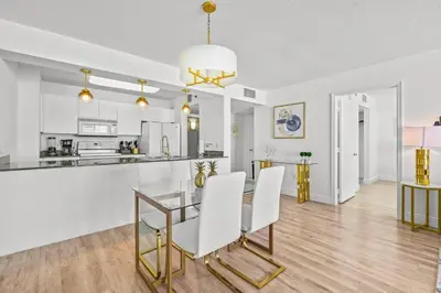 a dining room and kitchen with a glass table and white chairs at High Floor Unit Located in Brickell - Free Parking in Miami