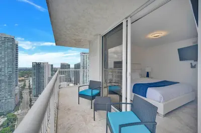 a bedroom with a bed and a balcony with a view at 40th Floor Priceless Unit Central Location in Miami
