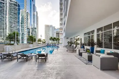 a pool in a building with chairs and tables at Amazing location W Parking in Miami in Miami