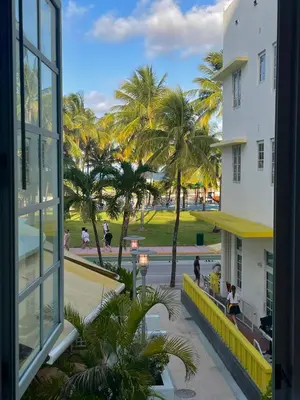 a view from a window of a building with palm trees at Beachfront Apt in Carlyle Hotel on Ocean Drive in Miami Beach
