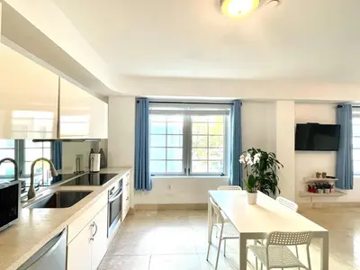 a kitchen with a table and a dining room at Beachfront Apt in Carlyle Hotel on Ocean Drive in Miami Beach