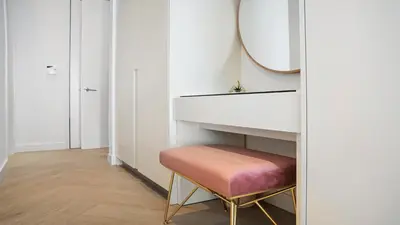 a bathroom with a vanity with a mirror and a stool at Ocean View Private Residence at South Beach - 804 in Miami Beach