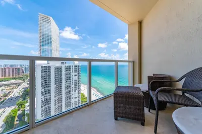 a balcony with a table and chairs and the ocean at 16699 Collins Ave Unit 2906 in La Perla in Miami Beach