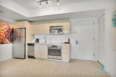 a kitchen with stainless steel appliances and a refrigerator at MODERN Resort Modern apartment 2 BR 2 BR POOL in Hallandale Beach