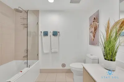 a white bathroom with a toilet and a bath tub at MODERN Resort Modern apartment 2 BR 2 BR POOL in Hallandale Beach