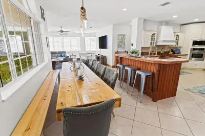 a kitchen with a long wooden table and chairs at UPSCALE MANSION IN THE HEART OF MIAMI WITH POOL in Miami