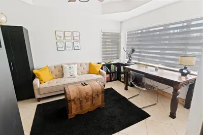a living room with a table and a couch and a desk at UPSCALE MANSION IN THE HEART OF MIAMI WITH POOL in Miami
