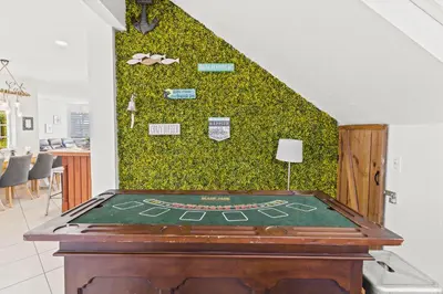 a ping pong table in a room with a green wall at UPSCALE MANSION IN THE HEART OF MIAMI WITH POOL in Miami