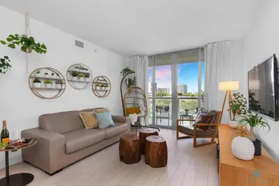 a living room with a couch and a tv at Tropical Apartment with Balcony - Pool - Up To 4 - Gym in Hallandale Beach