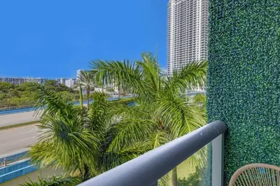 a balcony with palm trees and a tall building at Tropical Apartment - Balcony - Resort, Pool - Gym in Hallandale Beach