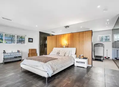 a bedroom with a large bed with a wooden headboard at Modern Northwest Vacation Rentals in Miami in Miami