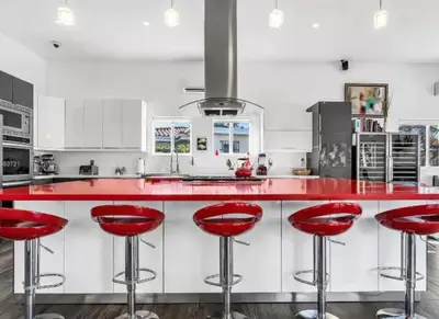 a kitchen with red bar stools at a red counter at Modern Northwest Vacation Rentals in Miami in Miami