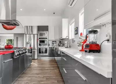 a large kitchen with white counters and stainless steel appliances at Modern Northwest Vacation Rentals in Miami in Miami
