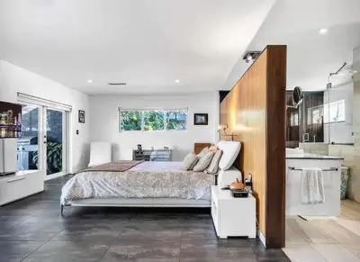a bedroom with a large bed and a kitchen at Modern Northwest Vacation Rentals in Miami in Miami