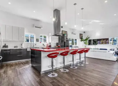 a kitchen with red bar stools at a counter at Modern Northwest Vacation Rentals in Miami in Miami