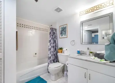 a bathroom with a tub and a toilet and a sink at Modern Vacation Apartment in Miami in Miami