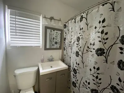 a bathroom with a toilet and a shower curtain at Small House Near Airport Beach - Wynwood in Miami